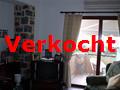 woonkamer met de deur naar het balkon