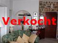 woonkamer en keuken gescheiden door een boog